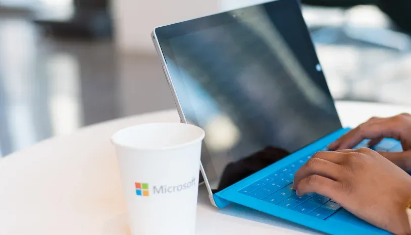 Laptop and a cup with Microsoft logo on it