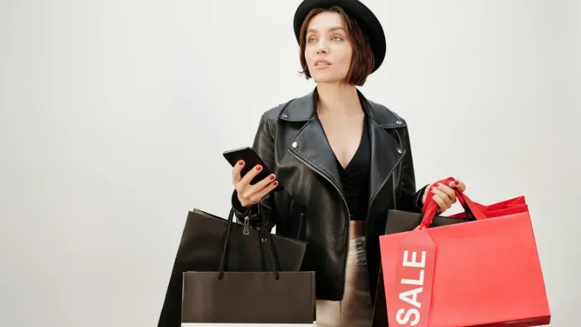 woman holding her cellphone while shopping