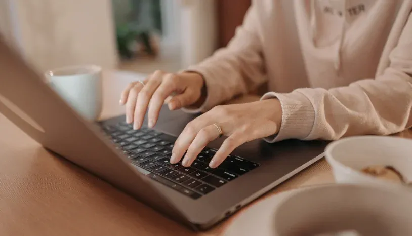 Woman tpying on a Mac laptop