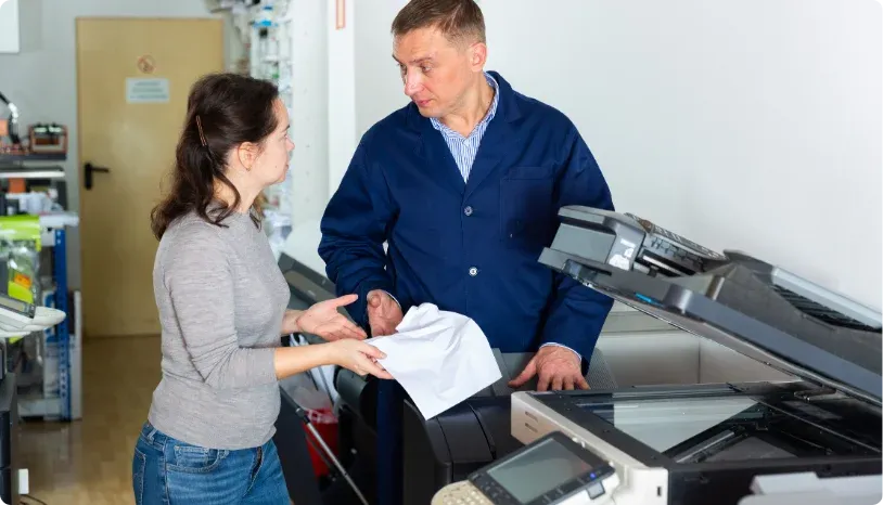 Man and woman beside a copier machine