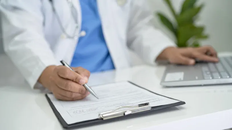 Doctor with laptop and record sheet