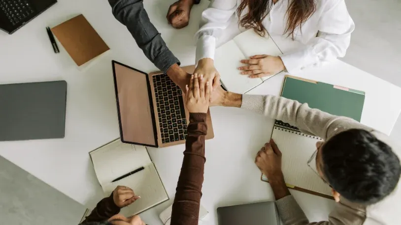 people at the office with their hands held together