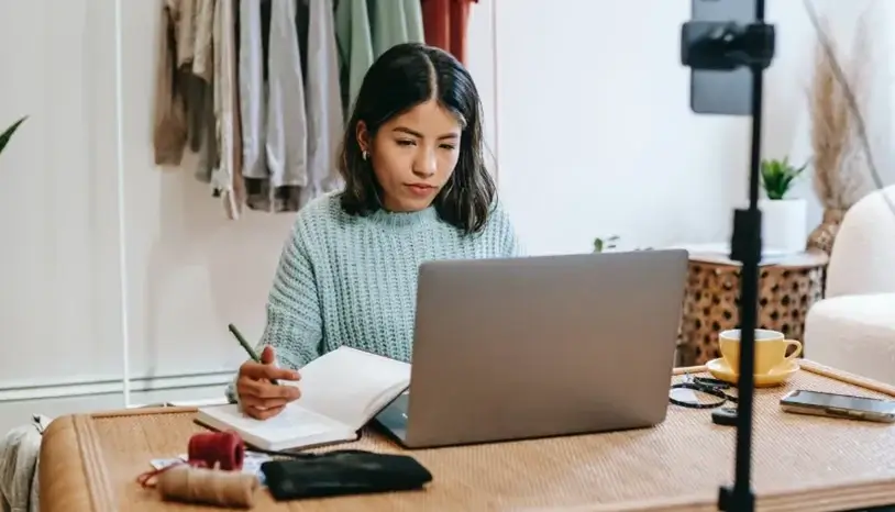 A woman working at home, sitting in front of her laptop 