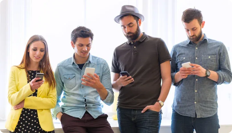 Four people looking at their mobile phones