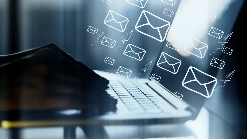 Hands on a laptop with mail icons floating